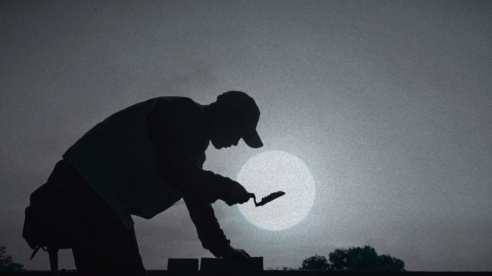 A mason setting brick by hand