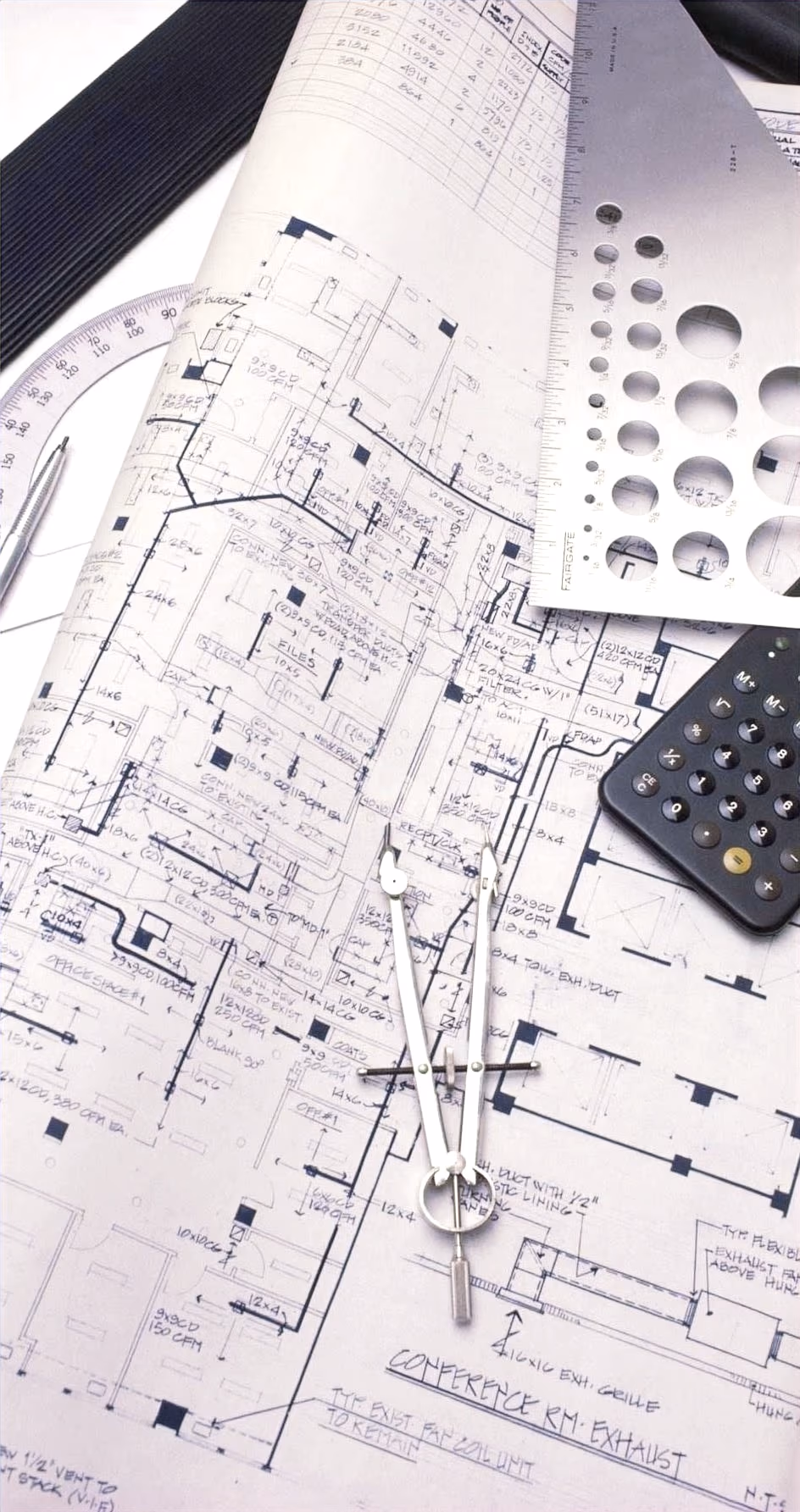 Architectural blueprints, a compass, and drafting tools laid out for outdoor project planning